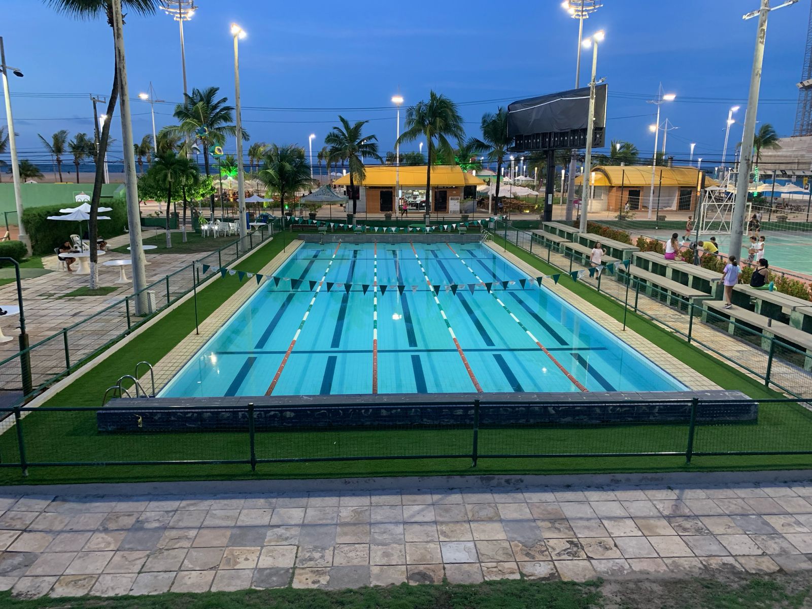 Grama sintética ao redor de piscina de clube