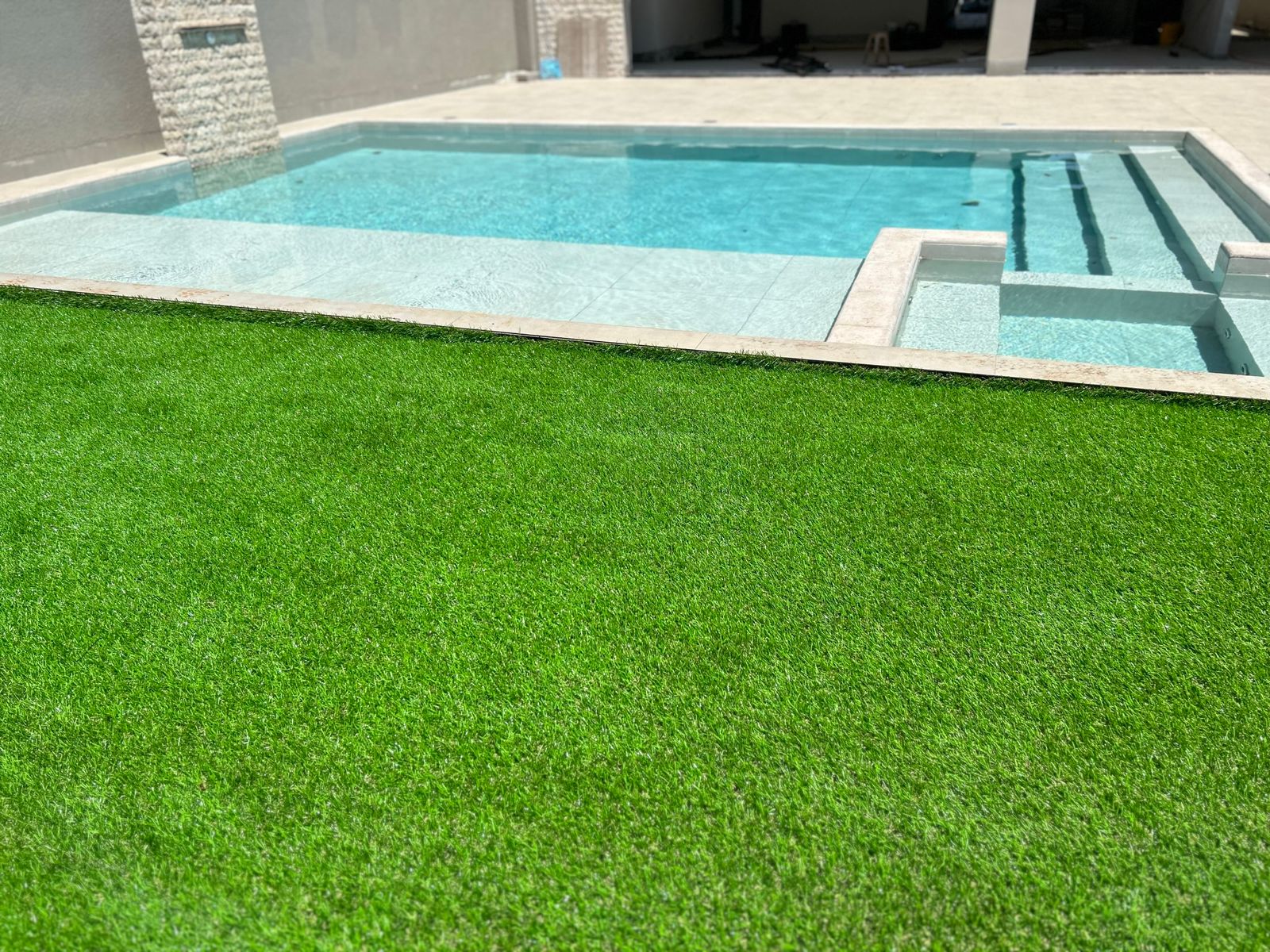 Grama sintética ao redor de piscina residencial